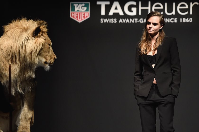 Cara Delevingne poses with a lion cub as she becomes TAG Heuer’s new ambassador