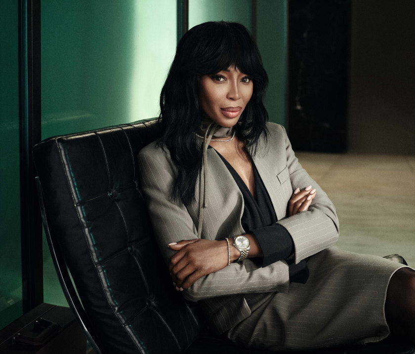 Naomi Campbell, seated, posing with Boss watch, bracelet and necklace