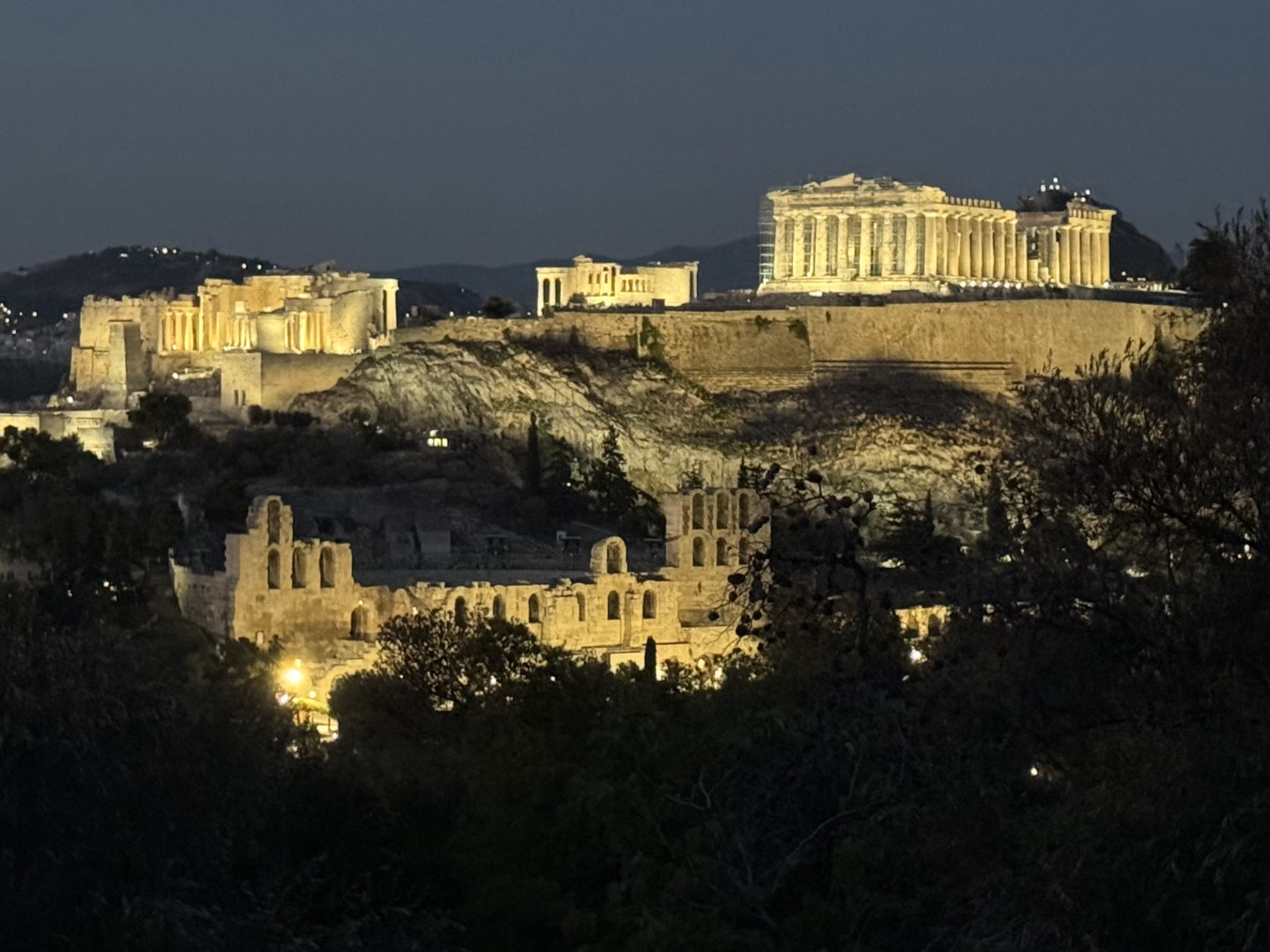 The Acropolis at night, with scaffolding to one side.